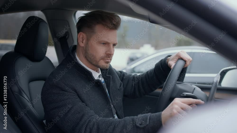 Handsome business man driving a car and looking out of the window Handsome business man driving a car and looking out of the window