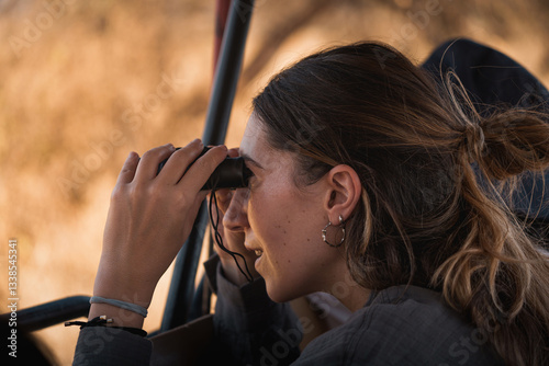 Tourist observing wildlife with binoculars during safari in tarangire national park