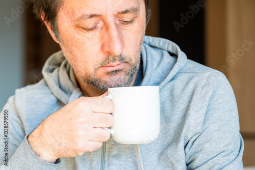 Relaxed causal man drinking coffee at home in the morning