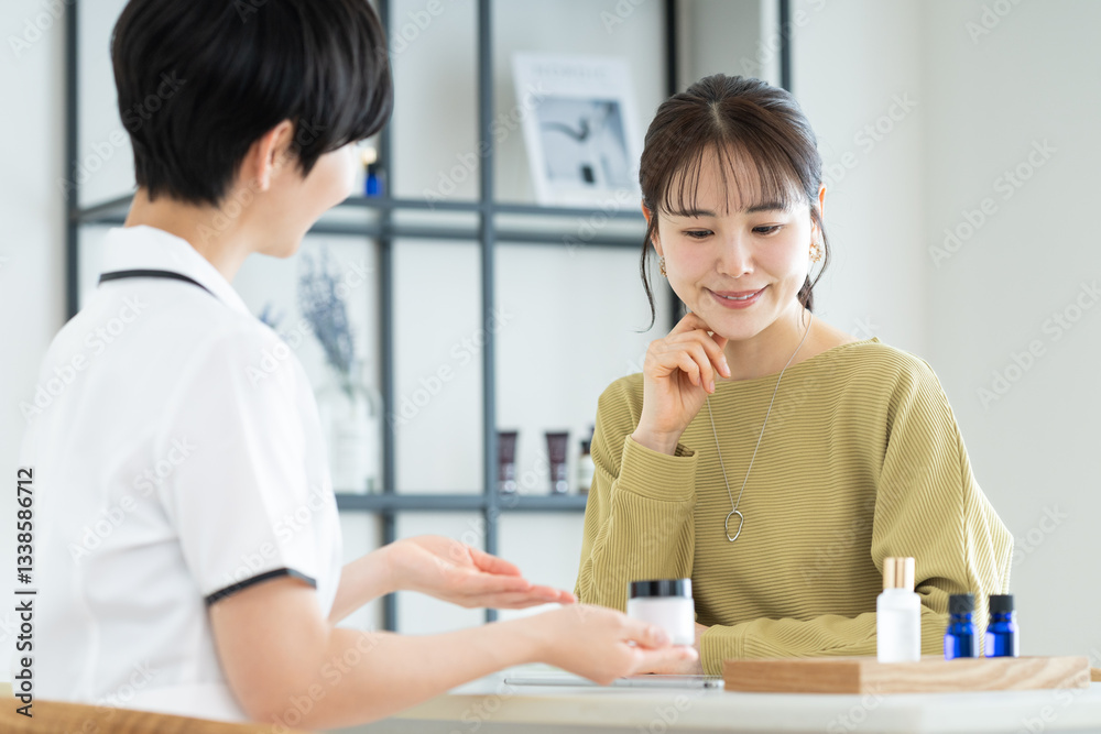 エステサロンで肌の相談をする若い女性 エステサロンで肌の相談をする若い女性