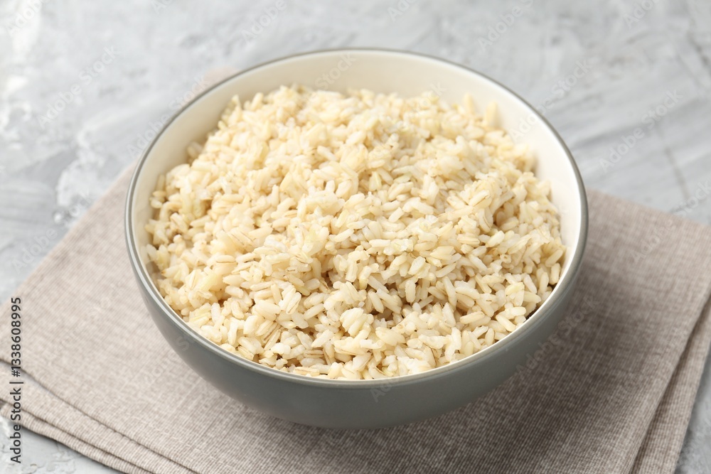 Delicious brown rice served on grey textured table, closeup Delicious brown rice served on grey textured table, closeup