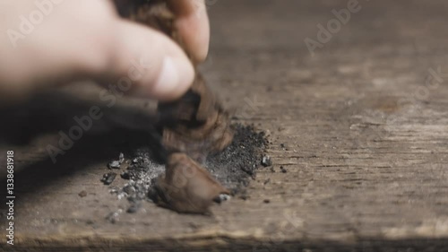 man putting cigar in ashtray with a wooden background.