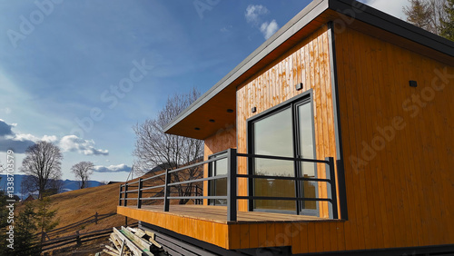 Wallpaper Mural Modern Wooden Cabin with Scenic Mountain View. A contemporary wooden cabin with large glass windows and a balcony, situated in a scenic hillside location with mountain views. Torontodigital.ca
