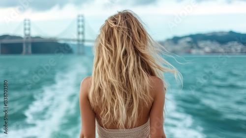 A woman gazes thoughtfully over the ocean waves from a scenic viewpoint, encapsulating serenity, reflection, and the beauty of nature as she embraces the calm surroundings.