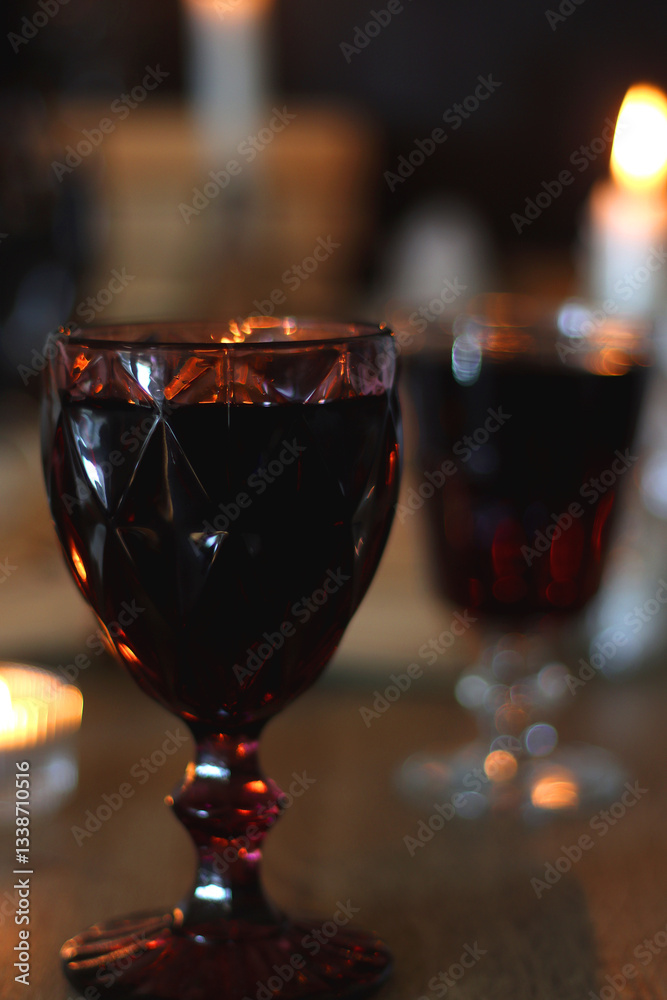 Books, lit candles, red wine, snacks and various deocration on the table. Dark academia or Halloween concept. Selective focus.