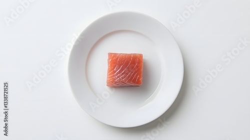 Obraz na płótnie A single cube of raw tuna rests on a white plate w salonie