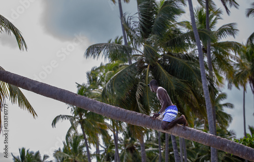Black Man Sitting on Palm Tree Trunk with White Smartwatch