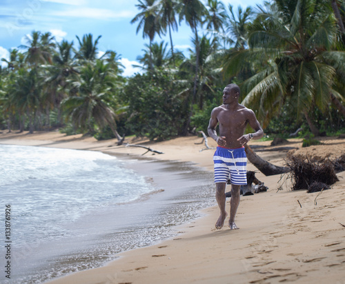 Black Man Running on Caribbean Beach in Rain with White Smartwatch