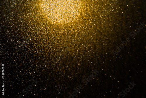 Blurred bokeh light sparkle on golden black background