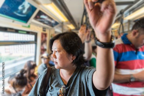 Asian woman travel on skytrain train in city photo