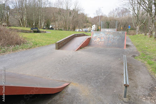 Skateboard park with ramps and apparatus in the outdoors against a cloudy sky