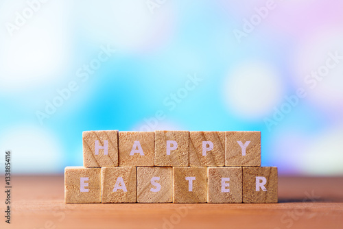 Wooden blocks spelling HAPPY EASTER with colorful Easter eggs and flowers in the blurred background. A festive and cheerful scene symbolizing Easter, spring, and holiday celebrations photo