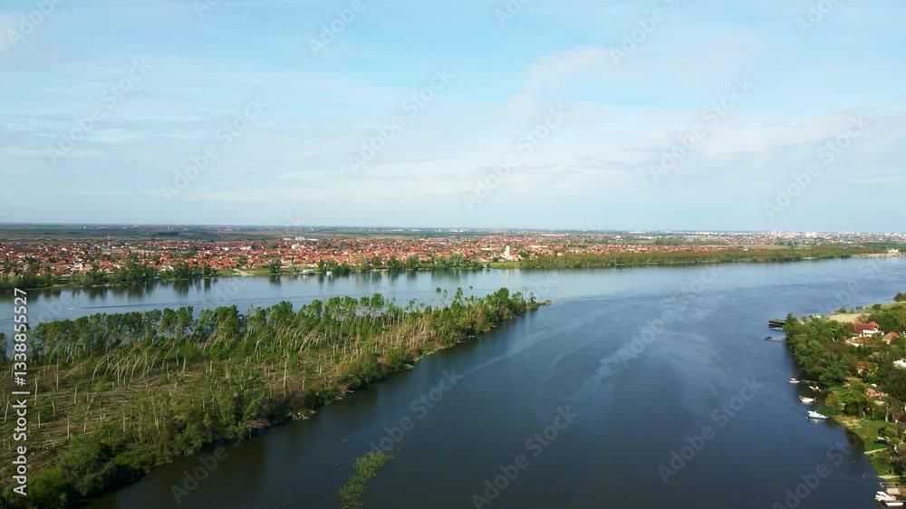 Beautiful river view with lush greenery and vibrant cityscape under clear blue sky Beautiful river view with lush greenery and vibrant cityscape under clear blue sky