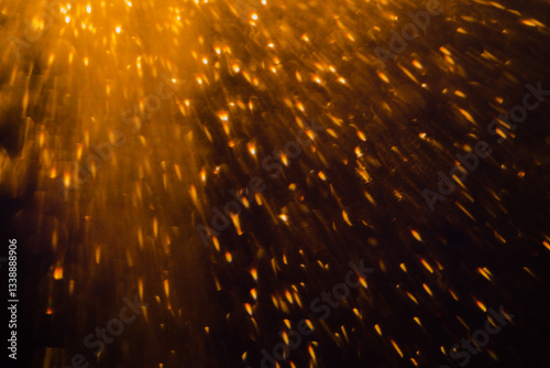 Blurred bokeh light sparkle on golden black background