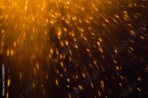 Blurred bokeh light sparkle on golden black background
