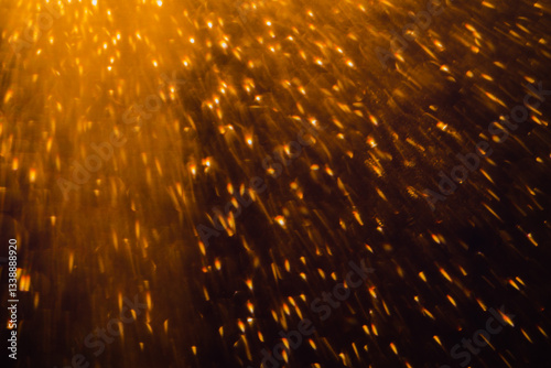 Blurred bokeh light sparkle on golden black background