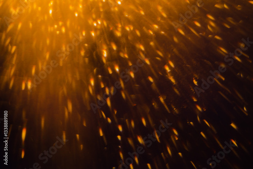 Blurred bokeh light sparkle on golden black background