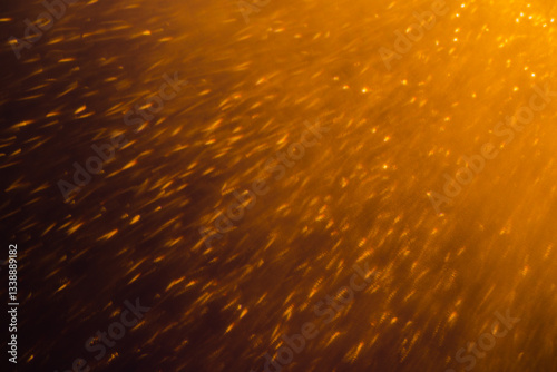 Blurred bokeh light sparkle on golden black background