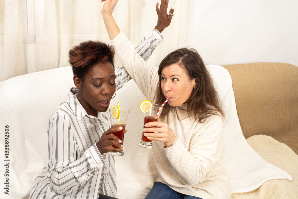 African black woman with short modern haircut and European white woman happily drinking juice. Friendship, joint actions, happiness together, teamwork,, healthy habits, joy of communication, positive African black woman with short modern haircut and European white woman happily drinking juice. Friendship, joint actions, happiness together, teamwork,, healthy habits, joy of communication, positive