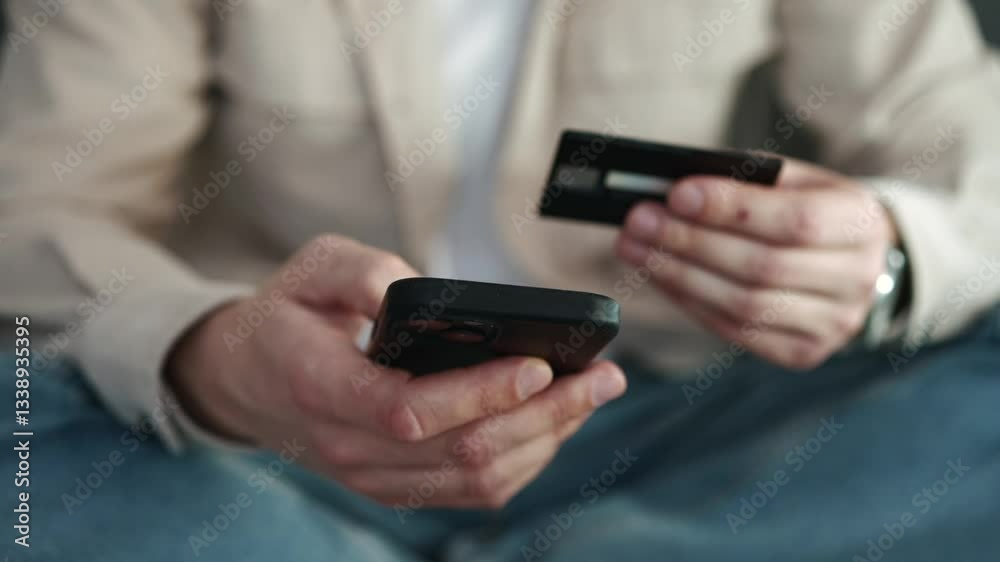 Cashless payment by bank card. A man with a bank card and a phone in his hands. Online shopping via the Internet. Payment by card. Shopping, online, card, bank, money Cashless payment by bank card. A man with a bank card and a phone in his hands. Online shopping via the Internet. Payment by card. Shopping, online, card, bank, money
