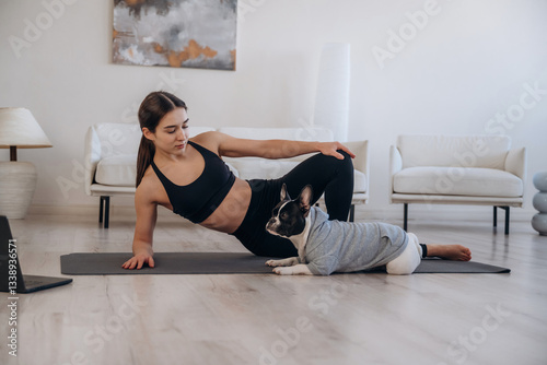 Resting on the floor. Woman with pug dog is doing yoga at home