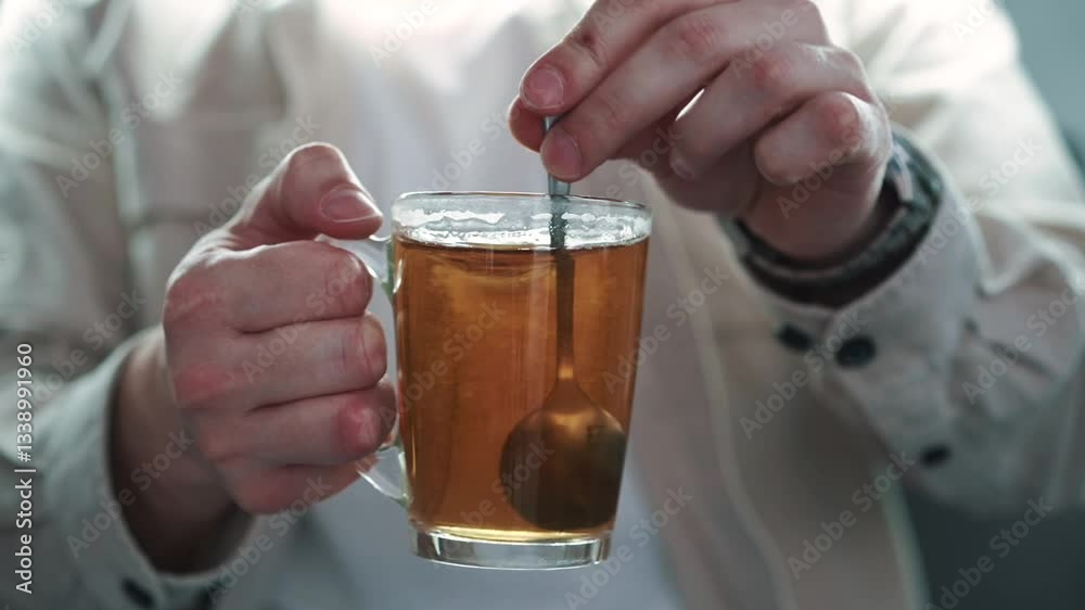 Hot tea in a transparent cup.
A man drinks tea in the morning.
Brewed tea in a glass.
Delicious tea.
A teaspoon in a glass of tea
