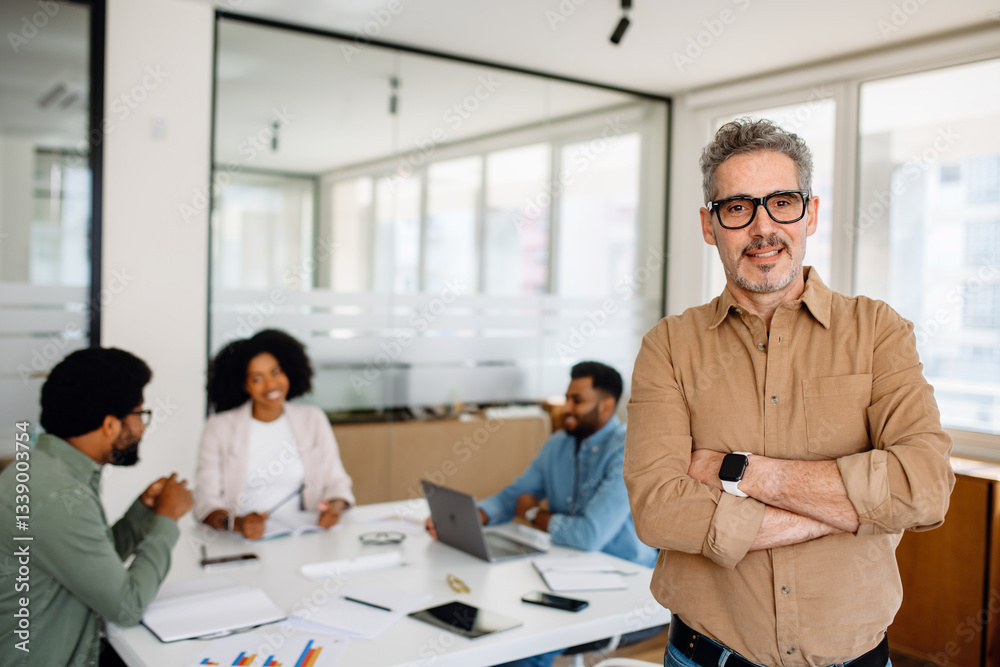 Obraz premium A senior executive in a brown shirt leading a business discussion in a corporate meeting. His leadership skills drive teamwork and productivity in a modern office environment