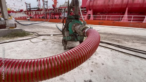 Close up Fuel or oil Transfer Through Industrial Pipeline from Trucks to Oil Tanker at Port