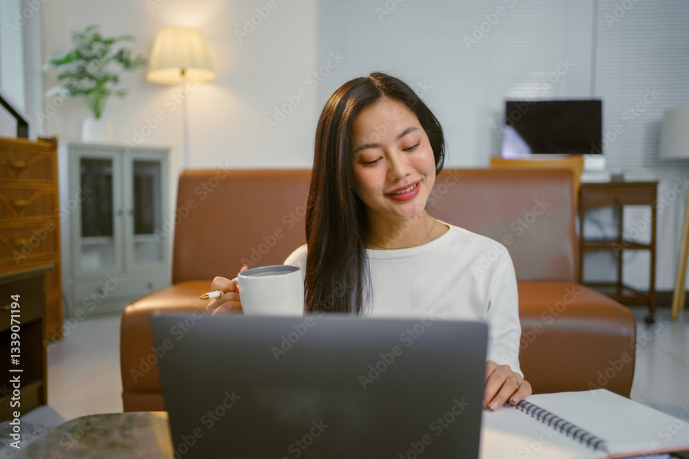 Freelancer relaxing at sunlit home workspace, drinking coffee and typing on laptop with cheerful expression Freelancer relaxing at sunlit home workspace, drinking coffee and typing on laptop with cheerful expression