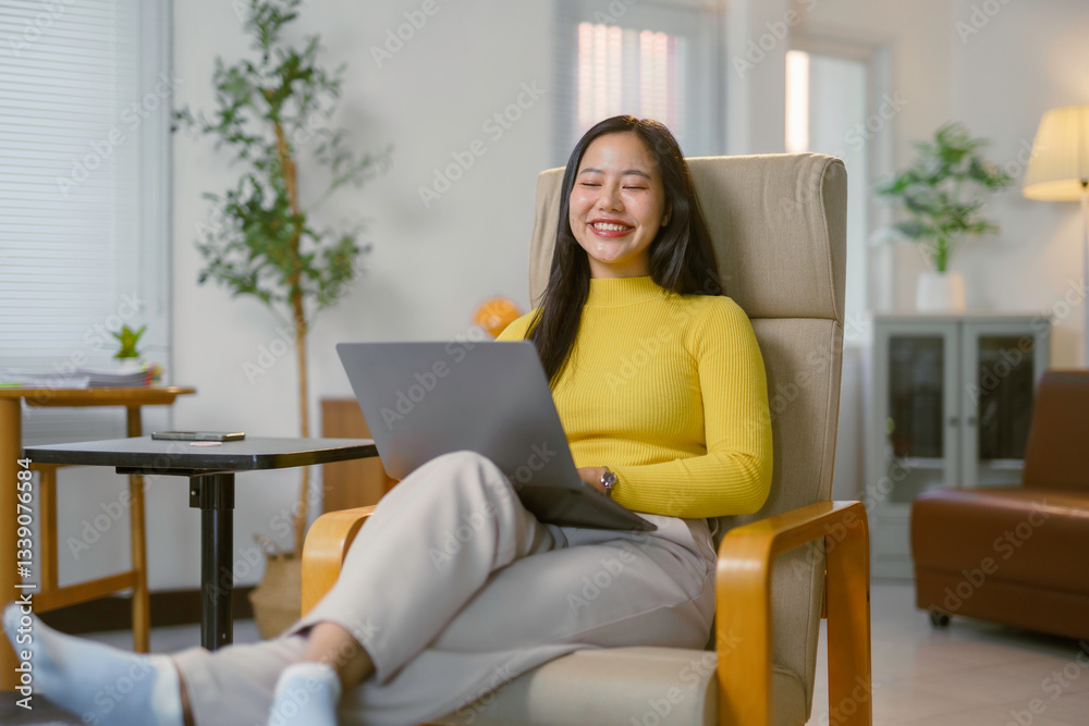 Freelancer working remotely, smiling while typing on laptop in cozy home environment Freelancer working remotely, smiling while typing on laptop in cozy home environment