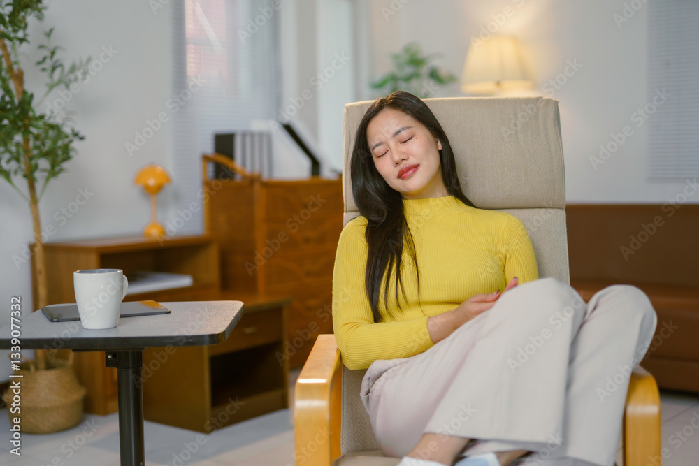 Asian businesswoman resting on armchair at home after finishing work, enjoying a moment of peace and quiet Asian businesswoman resting on armchair at home after finishing work, enjoying a moment of peace and quiet