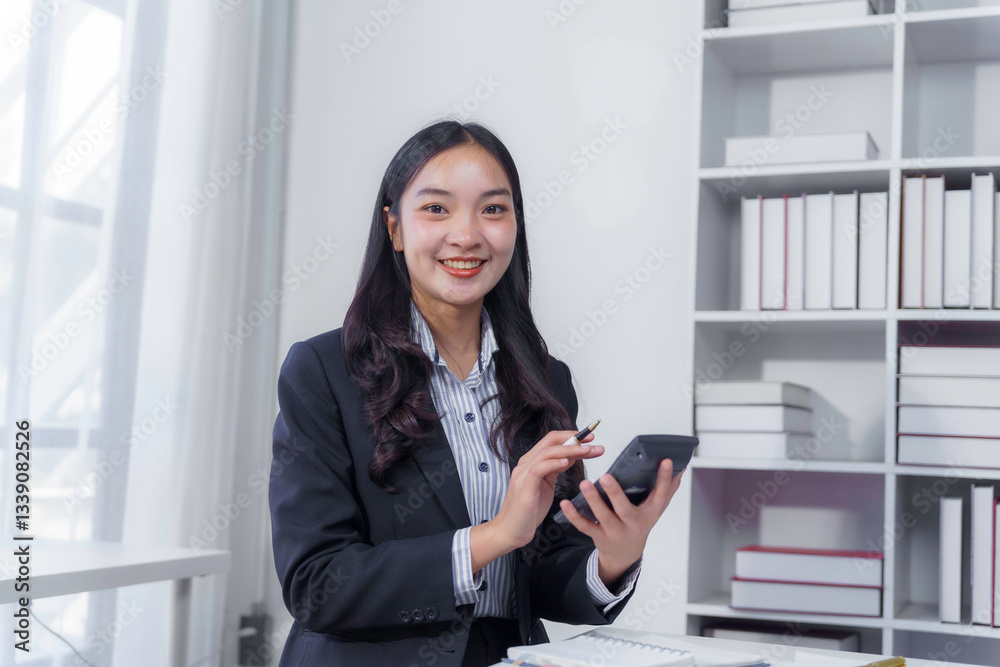Professional woman analyzing financial data, working confidently at modern desk with laptop and calculator Professional woman analyzing financial data, working confidently at modern desk with laptop and calculator