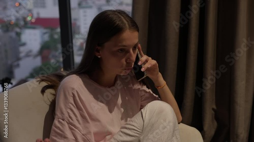 Close up portrait a woman speak on cell phone about work. Girl have call with client on background big city light. Business woman do business. Young woman talking on phone in hotel room at day.