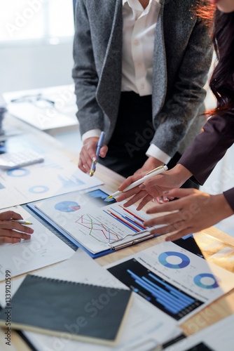 Business team analyzing financial charts and graphs, discussing company strategy and planning future investments