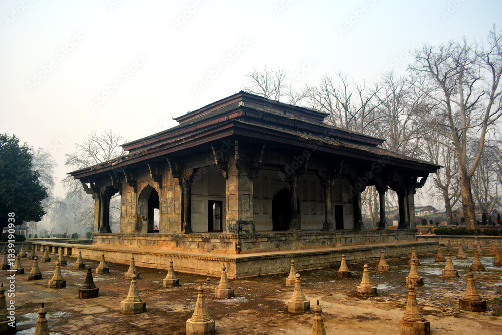 Pavilion at Shalimar Bagh with stone structures. Mughal architecture, cultural heritage, landscape photography. Formal garden, misty scene, Srinagar landmark, capturing the history of Mughal garden Pavilion at Shalimar Bagh with stone structures. Mughal architecture, cultural heritage, landscape photography. Formal garden, misty scene, Srinagar landmark, capturing the history of Mughal garden