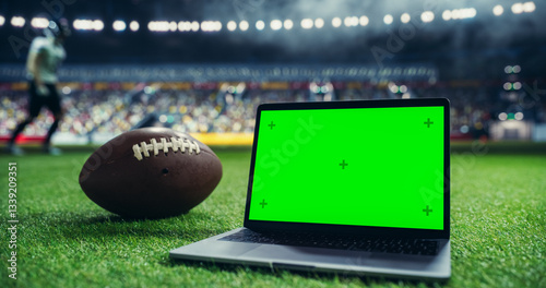 Φωτογραφία Laptop Computer with a Green Screen Mock Up Display Positioned Next to an American Football on a Stadium Pitch at Night