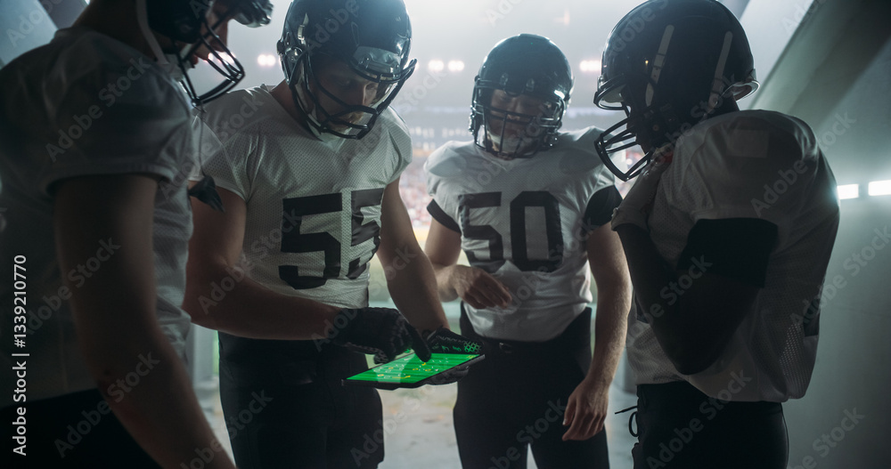 Fototapeta premium American Football Players Using Tablet Computer to Go Over Game Strategy Before Walking on Stadium Filled with Energetic Sports Fans and Team Supporters. Multiethnic Footballers Getting Ready