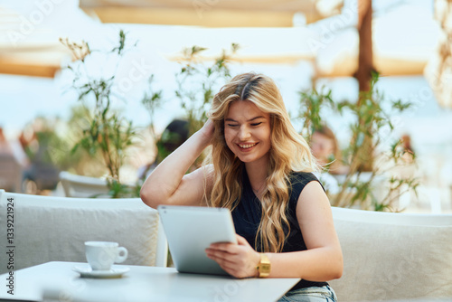 Businesswoman with Blonde Hair Sitting in a Caffee, Using a Tablet for Work. Free Download Businesswoman with Blonde Hair Sitting in a Caffee, Using a Tablet for Work. - GFXLoad