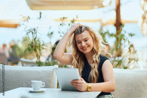 Businesswoman with Blonde Hair Sitting in a Caffee, Using a Tablet for Work. Free Download Businesswoman with Blonde Hair Sitting in a Caffee, Using a Tablet for Work. - GFXLoad