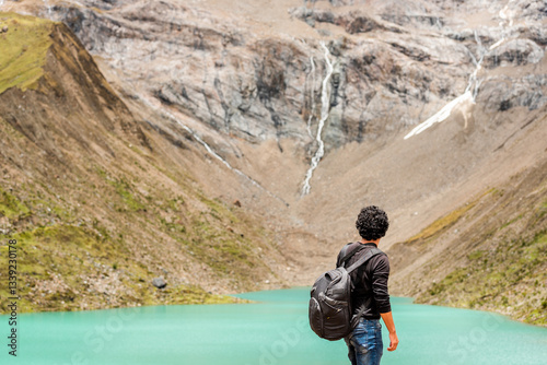 young man looking at humantay lagoon in Cusco Peru