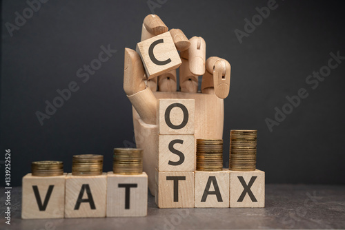 Obraz na płótnie sztuczna dłoń układająca napisy dotyczące finansów: VAT, COST, TAX w salonie