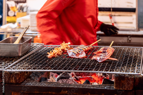 Photography Juicy seafood skewers with whole squid and crispy octopus tentacles are slowly c