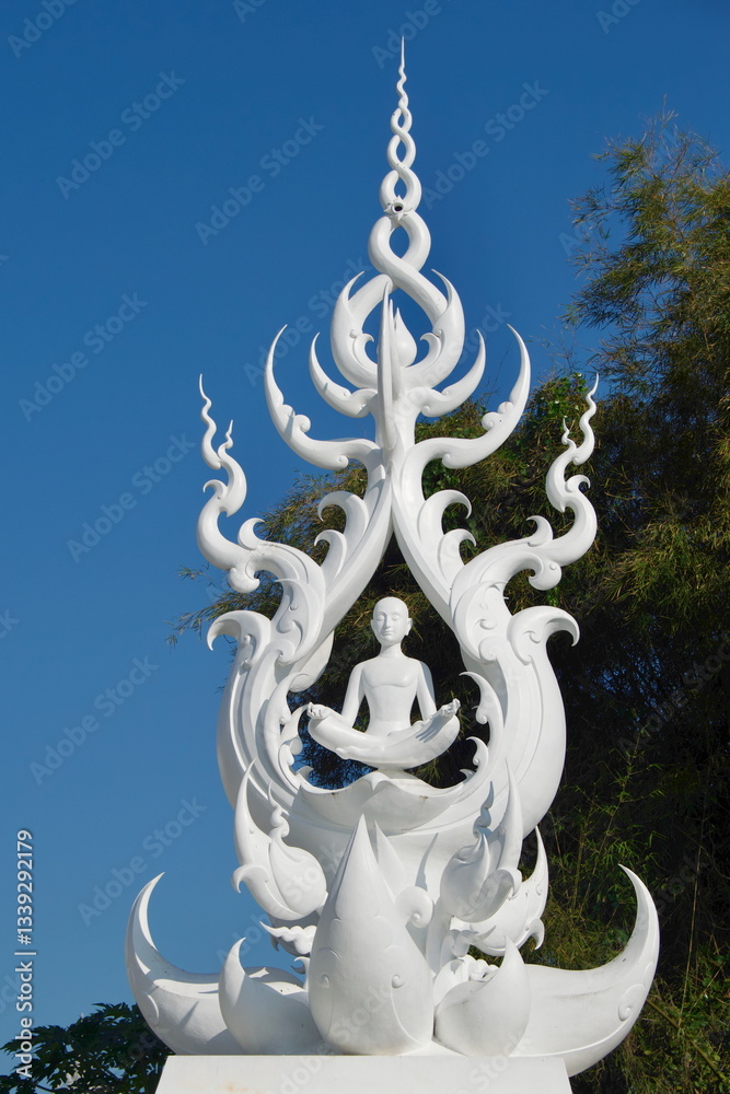 White statue of sitting Buddha in meditation in the White Temple in Thailand