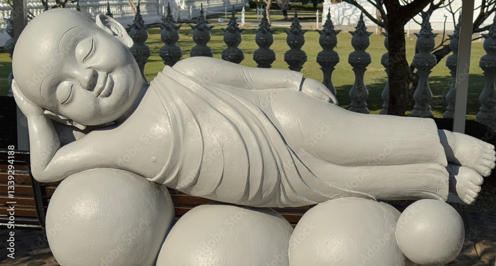 Statues of little monk meditating in the White Temple in Thailand
