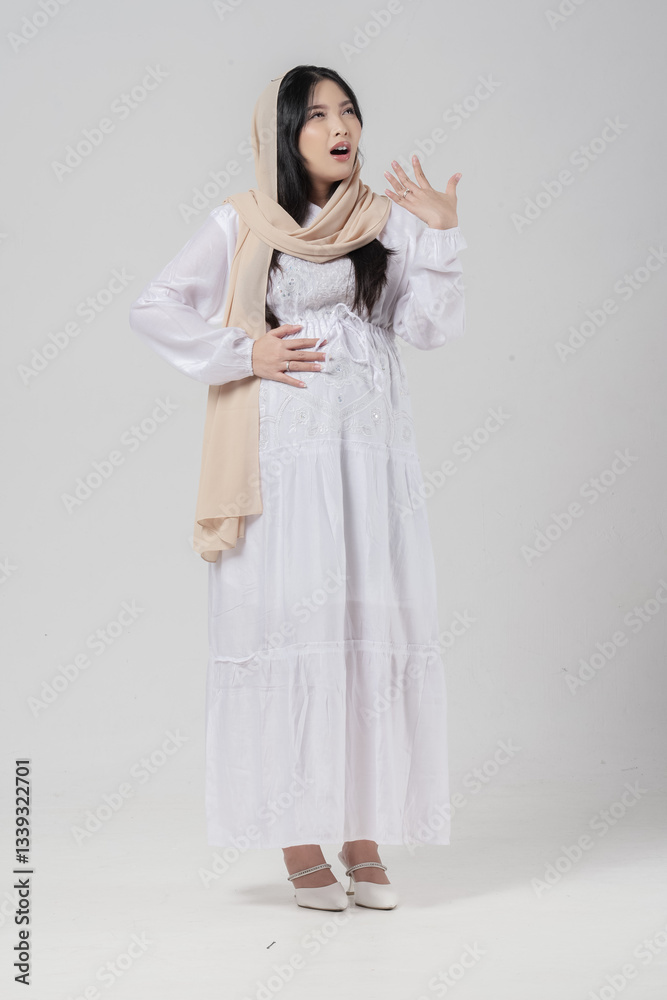 Asian Muslim pregnant woman raising hand to fan herself feeling hot due to summer while fasting. Asian Muslim pregnant woman raising hand to fan herself feeling hot due to summer while fasting.