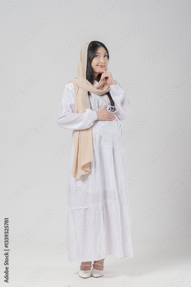 Thoughtful Asian Muslim pregnant woman wearing headscarf veil hijab focused and thinking hard. Thoughtful Asian Muslim pregnant woman wearing headscarf veil hijab focused and thinking hard.