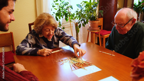 Obraz na płótnie Happy grandmother having fun with her family playing mikado at home w salonie