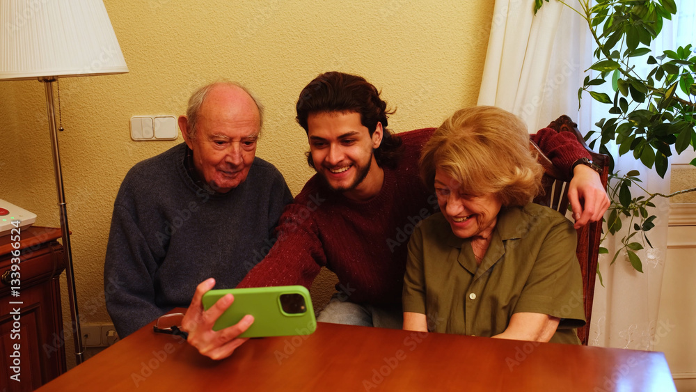 Elderly couple and their grandson using a smartphone for video call at home