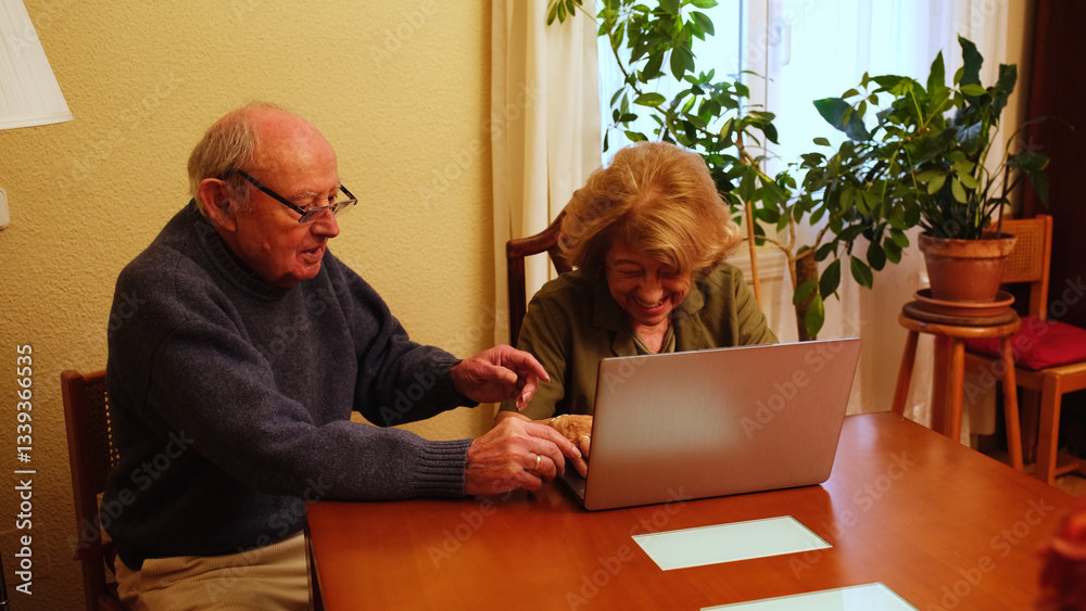 Senior couple browsing internet on laptop, happy and smiling, enjoying technology in their home