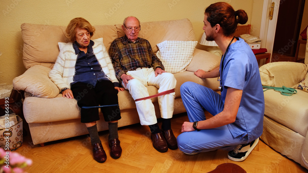 Senior couple exercising with resistance band, guided by healthcare professional during home visit